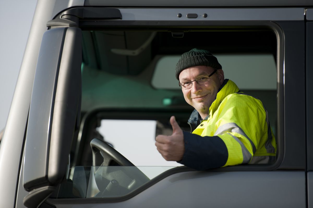  Photo of a Cooks Waste employee giving a thumbs up out of the window of his Cooks Waste garbage truck.